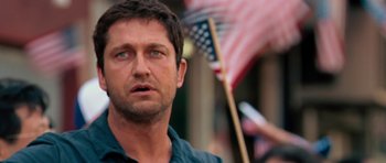 Movie still from “The Bounty Hunter” (2010), directed by Andy Tennant – A man with a flag in the background; Close Up shot, Over the shoulder angle