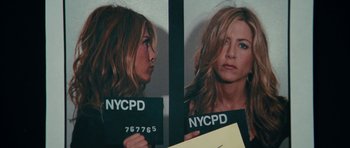 Movie still from “The Bounty Hunter” (2010), directed by Andy Tennant – A mugshot of jennifer aniston in a police station; Close Up shot, Low angle