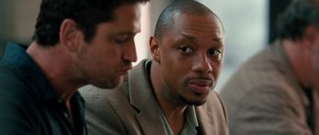 Movie still from “The Bounty Hunter” (2010), directed by Andy Tennant – Two men are looking at each other in a room; Close Up shot, Over the shoulder angle