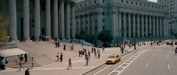 Movie still from “The Bounty Hunter” (2010), directed by Andy Tennant – A yellow taxi cab driving down a street next to a building; Extreme Wide shot, High angle