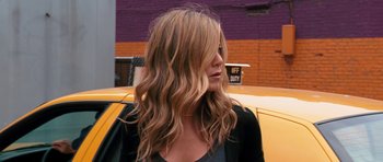 Movie still from “The Bounty Hunter” (2010), directed by Andy Tennant – A woman with long blonde hair sitting in front of a yellow taxi cab; Close Up shot, Over the shoulder angle