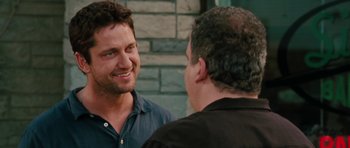 Movie still from “The Bounty Hunter” (2010), directed by Andy Tennant – Two men talking to each other in front of a brick wall; Close Up shot, Over the shoulder angle