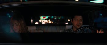 Movie still from “The Bounty Hunter” (2010), directed by Andy Tennant – A man sitting in the back of a car at night; Medium shot, Over the shoulder angle