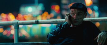 Movie still from “The Bounty Hunter” (2010), directed by Andy Tennant – A man sitting on top of a bench holding a baseball bat; Close Up shot, Low angle