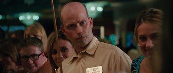 Movie still from “The Bounty Hunter” (2010), directed by Andy Tennant – A man in a tan shirt holding a stick; Close Up shot, Over the shoulder angle