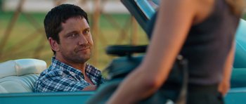 Movie still from “The Bounty Hunter” (2010), directed by Andy Tennant – A person sitting in a car; Close Up shot, Over the shoulder angle