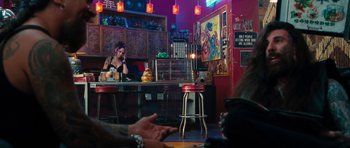 Movie still from “The Bounty Hunter” (2010), directed by Andy Tennant – A woman sitting at a table in front of a counter; Wide shot, Over the shoulder angle