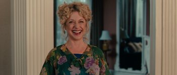 Movie still from “The Bounty Hunter” (2010), directed by Andy Tennant – A woman with curly hair smiling for the camera; Medium shot, Over the shoulder angle