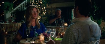 Movie still from “The Bounty Hunter” (2010), directed by Andy Tennant – A group of people sitting at a dinner table; Medium shot, Over the shoulder angle