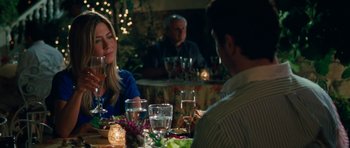 Movie still from “The Bounty Hunter” (2010), directed by Andy Tennant – A group of people sitting at a dinner table; Medium shot, Over the shoulder angle