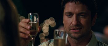 Movie still from “The Bounty Hunter” (2010), directed by Andy Tennant – A person holding a glass of wine; Close Up shot, Over the shoulder angle