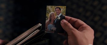 Movie still from “The Bounty Hunter” (2010), directed by Andy Tennant – A person holding a picture of a man and woman; Extreme Close Up shot, High angle