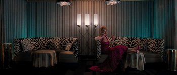 Movie still from “The Bounty Hunter” (2010), directed by Andy Tennant – A woman sitting on top of a couch holding a wine glass; Wide shot, Low angle