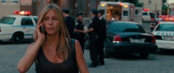 Movie still from “The Bounty Hunter” (2010), directed by Andy Tennant – A woman walking down a street with a group of police officers; Close Up shot, Over the shoulder angle