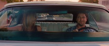 Movie still from “The Bounty Hunter” (2010), directed by Andy Tennant – Two women sitting in the back seat of a car; Medium shot, Over the shoulder angle