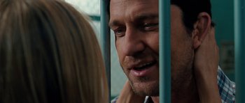 Movie still from “The Bounty Hunter” (2010), directed by Andy Tennant – A person behind a metal fence; Close Up shot, Over the shoulder angle