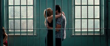 Movie still from “The Bounty Hunter” (2010), directed by Andy Tennant – A man and a woman hugging in front of a jail cell; Wide shot, Low angle