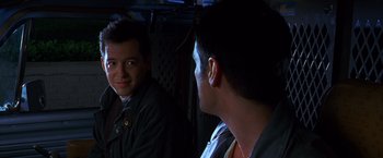 Movie still from “The Cable Guy” (1996), directed by Ben Stiller – A man standing next to another man in front of a mirror; Close Up shot, Over the shoulder angle
