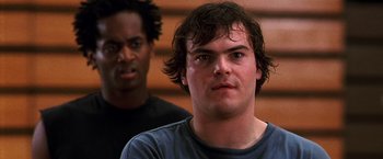 Movie still from “The Cable Guy” (1996), directed by Ben Stiller – A man in a blue shirt and a man in a black shirt; Close Up shot, Low angle