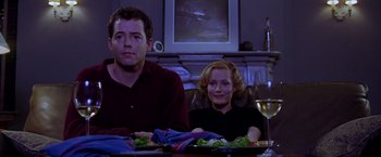 Movie still from “The Cable Guy” (1996), directed by Ben Stiller – A man and a woman sitting at a dinner table; Medium shot, Low angle