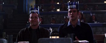 Movie still from “The Cable Guy” (1996), directed by Ben Stiller – A couple of men sitting next to each other at a table; Medium shot, Low angle