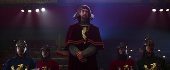 Movie still from “The Cable Guy” (1996), directed by Ben Stiller – A man dressed as a medieval knight standing in front of two other men; Medium shot, Low angle