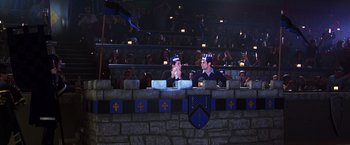 Movie still from “The Cable Guy” (1996), directed by Ben Stiller – Two men are sitting in front of a crowd; Wide shot, High angle