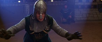 Movie still from “The Cable Guy” (1996), directed by Ben Stiller – A man wearing a helmet and holding a sword; Medium shot, Low angle