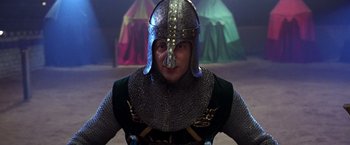 Movie still from “The Cable Guy” (1996), directed by Ben Stiller – A man wearing a helmet and a chain mail outfit; Close Up shot, Low angle