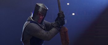 Movie still from “The Cable Guy” (1996), directed by Ben Stiller – A man dressed as a medieval knight holding a sword; Medium shot, Low angle