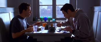 Movie still from “The Cable Guy” (1996), directed by Ben Stiller – Two people sitting at a table with cups of tea; Medium shot, High angle