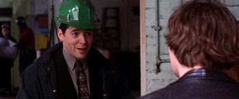 Movie still from “The Cable Guy” (1996), directed by Ben Stiller – A man wearing a hard hat and a tie; Close Up shot, Over the shoulder angle