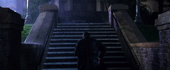 Movie still from “The Cable Guy” (1996), directed by Ben Stiller – A man walking down a set of stairs at night; Wide shot, Low angle