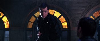 Movie still from “The Cable Guy” (1996), directed by Ben Stiller – A man standing in front of a stained - glass window; Medium shot, Low angle