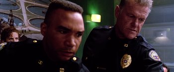 Movie still from “The Cable Guy” (1996), directed by Ben Stiller – Two police officers standing next to each other; Close Up shot, Low angle