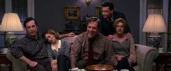 Movie still from “The Cable Guy” (1996), directed by Ben Stiller – A group of people sitting on top of a couch; Medium shot, High angle