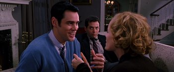 Movie still from “The Cable Guy” (1996), directed by Ben Stiller – A group of people sitting in a living room talking to each other; Medium shot, Over the shoulder angle