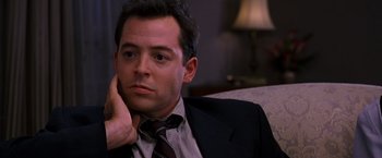 Movie still from “The Cable Guy” (1996), directed by Ben Stiller – A person wearing a suit and tie; Close Up shot, Over the shoulder angle