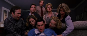 Movie still from “The Cable Guy” (1996), directed by Ben Stiller – A group of people are gathered around a man; Medium shot, Overhead angle