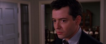 Movie still from “The Cable Guy” (1996), directed by Ben Stiller – A person wearing a suit and tie; Close Up shot, Over the shoulder angle