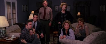 Movie still from “The Cable Guy” (1996), directed by Ben Stiller – A group of people sitting and standing in a living room; Wide shot, High angle