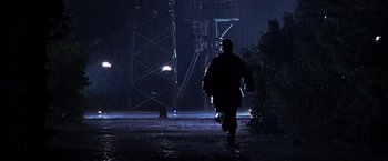 Movie still from “The Cable Guy” (1996), directed by Ben Stiller – A man walking in the rain at night; Wide shot, Low angle
