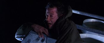 Movie still from “The Cable Guy” (1996), directed by Ben Stiller – A man with a knife in his hand is holding something; Close Up shot, Low angle