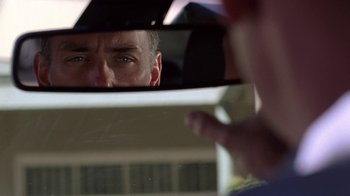 Movie still from “Breaking Bad” (2008), created by Vince Gilligan – A man looking at himself in the mirror of a car; Extreme Close Up shot, Low angle