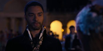 Movie still from “Bridgerton” (2020), created by Chris Van Dusen – A man in a black jacket standing in front of a building; Close Up shot, Over the shoulder angle