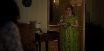 Movie still from “Bridgerton” (2020), created by Chris Van Dusen – A woman in a green dress standing in a room; Medium shot, High angle