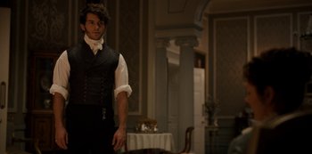 Movie still from “Bridgerton” (2020), created by Chris Van Dusen – A man standing in front of a dining room table; Medium shot, Over the shoulder angle