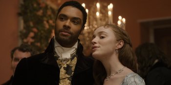 Movie still from “Bridgerton” (2020), created by Chris Van Dusen – A man and a woman standing next to each other in front of a chandelier; Close Up shot, Over the shoulder angle