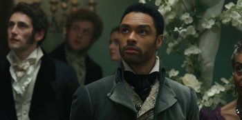 Movie still from “Bridgerton” (2020), created by Chris Van Dusen – A man standing in front of some other people; Close Up shot, Over the shoulder angle