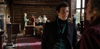 Movie still from “Bridgerton” (2020), created by Chris Van Dusen – A man in a black suit standing in a library; Medium shot, Over the shoulder angle